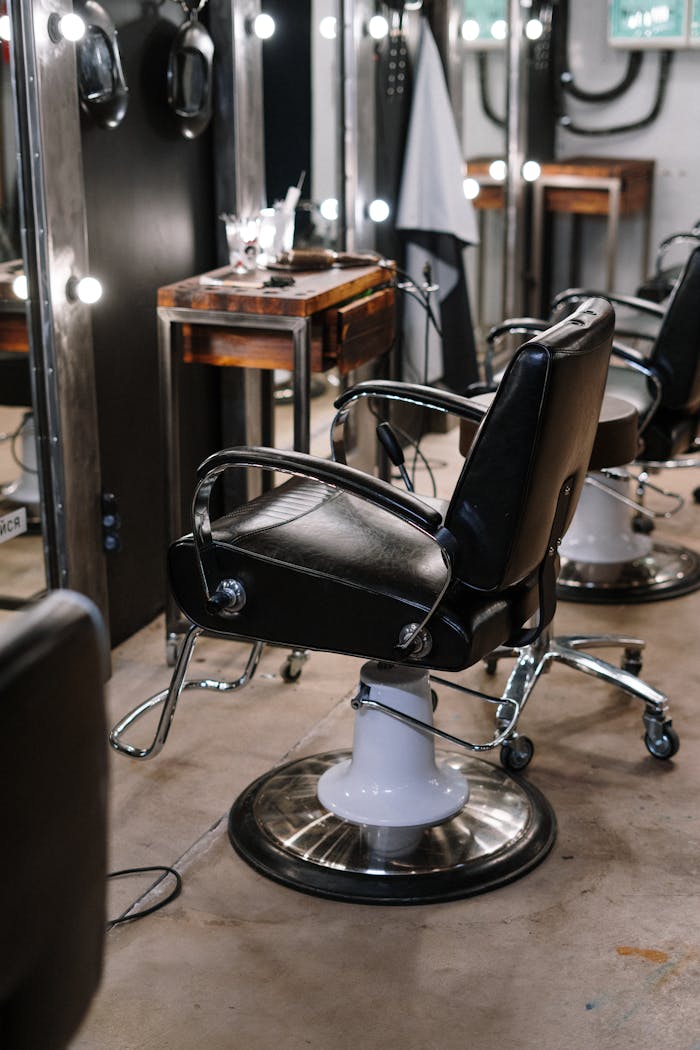Empty barber shop with sleek chairs and illuminated mirrors.